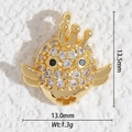 Gros plan d'un pendentif oiseau doré de 13,5mm serti de zircons et d'yeux en pierres bleues - Oiseau de Dessin Animé Strass (DZ-3230)