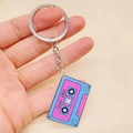 Retro cassette tape keychain with vibrant blue and pink vaporwave style and Good Vibes text - Vaporwave Blue and Pink Cassette Style (C)