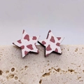 Detail von sternförmigen Ohrringen mit Kuhmuster auf einer Travertinstein-Fläche - Brown White Cow Print Star (JE0816C)