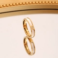 Detailansicht eines Goldrings mit Muscheleinlage und drei glitzernden Zirkonia-Steinen - US 5 / Gold