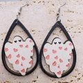 Dettaglio di orecchini in legno con fantasma e cuore rosso su superficie in pietra - Stile Fantasma con Cuori Rossi (JE0850E)