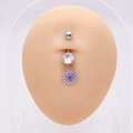 Detalle de piercing para ombligo de acero con colgante de girasol azul en un modelo - Girasol Ojo Turco (E)