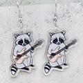 Detalle de pendientes de acrílico con mapache y guitarra eléctrica sobre piedra - Estilo Mapache Con Guitarra Eléctrica (JE0980H)