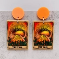 Detail of tarot style earrings featuring hands holding a taco with cactus accents - The Taco (JE1040C) / Orange