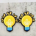 Detailed top view of creative yellow light bulb earrings with blue base on grey surface - Creative Lightbulb Style (JE1361D)