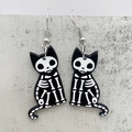 Detail shot of acrylic skeleton cat earrings with silver hooks for Halloween costume - B&W Cat Skeleton (JE1423B)