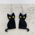 Detailed view of glossy black acrylic cat earrings with vibrant yellow eyes on grey texture - Yellow Eye Black Cat (JE1423A)