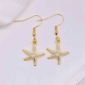 Detailed close-up of golden starfish hook earrings with white enamel finish and sea motifs - White Center Golden Starfish (JE1614S)