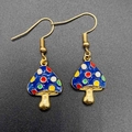 Détail macro de boucles d'oreilles champignon en émail bleu avec points colorés et métal doré - Style Champignon Bleu à Pois Multicolores (JE1613J)