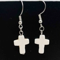 Détail de boucles d'oreilles bohèmes avec pendentif croix et crochets argentés sur fond noir - Style Croix Blanche (JE1626L)