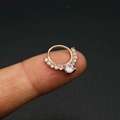 Micro-geplaveide zirkonia neusring en oorring in roségoud op een vingertop - Roségouden Stijl (JE0405C)