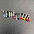 Macro shot of 16 colorful acrylic cone labret studs set on a textured grey surface - B# Solid Color Spike Head Labret Stud