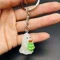 Close-up of a luminous ghost figurine holding a small Christmas tree on a keychain - Ghost With Christmas Tree Style (JE1521A)