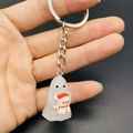 Detail of glow-in-the-dark resin ghost keychain with a tiny snowman held in hand - Ghost With Snowman Style (JE1521C)