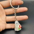 Luminous Halloween ghost keychain made of white resin holding a colorful lollipop - Ghost With Lollipop Style (JE1521F)