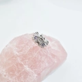 Detailed macro view of a silver floral bead with purple gemstones on a pink quartz stone - 11.5 (5mm Hole) / Platinum Plated Purple Zirconia