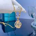 Collana dorata elegante con pendente a luna e cuore, pietra mobile e catena a foglie - Oro