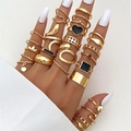 Detail van 27-delige gouden ringenset met hart en vlinder bedeltjes aan een modellenhand - Verstelbaar Open / Zwart Emaille Vlinder Hart Stijl (HS701-37) / 27-delige set / Goud
