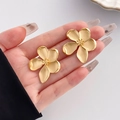 Golden five-petal flower stud earrings with a matte satin finish held in hand - Flower Shape Style (HS1061-1)