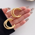 Matte gold layered geometric earrings with interlocking double circles in hand - Double Loop Round Style (HS1061-2)
