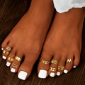 Close-up of golden toe ring set with wave and heart designs on dark skin with white nails - Hollow Combination (HS1449-1) / Gold