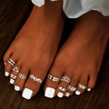 10-piece silver toe ring set featuring star and moon designs on tanned skin with white nails - Silver Style (HS1447-2)