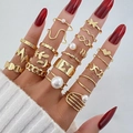 17-piece gold geometric ring set with butterfly, heart, and pearl details on model hand - Gold Butterfly Pearl Set (HS1488-6)