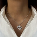Silver heart-shaped necklace with letter B and floral details on a female model - Letter B / Silver