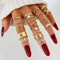 Set de anillos dorados bohemios con mariposas y estrellas en una mano femenina - HS1621-4