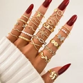 Set di 23 anelli dorati con farfalle e perle indossati da una modella - Stile Oro (HS1546-33) / Confezione da 25