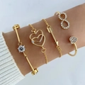 Detail van vijfdelige gouden armbandset met hartvormige bedeltjes en zirkoonkristallen - 5-delige Set (Zirconia T-vormige Armband, Hol Dubbel Hart, Pijl, Oneindigheid, Hart) / Goud Stijl 1 (HS1667-1)