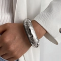 Macro shot of silver wide irregular textured bracelet on a woman wrist - Concave-Convex Round Bracelet / Silver