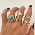 Set di anelli boho dorati con pietre verde smeraldo e perle indossati sulla mano - HS1680-9