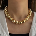 Detailed view of polished large gold bead necklace on a model wearing white shirt - Gold Large Diameter Metal Round Bead Necklace (HS1979-8)