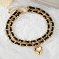 Detalle de collar de doble capa con colgante de corazón dorado y cinta de cuero negro - Estilo Corazón Doble Capa Tejido de Cuero Dorado
