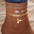 Four-piece gold layered anklet set with blue beads and heart charms on a beach - Golden Multilayer Bead Leaf Combo (HS1926-1)