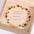 Detail view of a gold leaf bracelet with blue gemstones and marquise crystals in a box - Gold (Dark Blue)