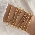 Stackable gold wave bangles with textured hammered finish on a model's wrist - Multi-circle Hammered Thin Line Style (HS1974-9)