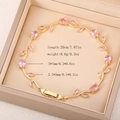 Detailed view of golden vine bracelet with pink gems and jewelry clasp in a gift box - Gold Pink