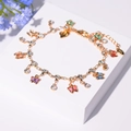 Gros plan de breloques papillons colorées et cristaux sur bracelet chaîne doré - Style Papillon Multicolore (SL419026)