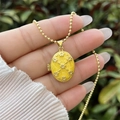 Macro detail of a 18K gold plated oval flower locket with yellow enamel on a bead chain - 18K Gold / Yellow