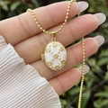 Detail of 18K gold plated locket with floral motif on pearl white inlay - 18K Gold / White