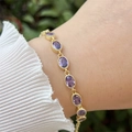 Detail of model wearing a vintage gold-plated bracelet with oval purple gemstones - Purple (3)