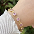 Detail showing the square pink zircon stones and 18k gold plated bezel on the wrist - Pink