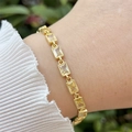 Nahaufnahme eines 18k vergoldeten Armbands mit gelben Zirkonia auf dem Handgelenk - Hellgelb