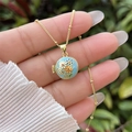 Primer plano de cadena dorada con un relicario de esmalte azul y motivos florales - Estilo Floral Azul Claro (1) / Chapado en oro 18K