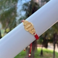 Detail view of 18K gold plated Saint Jude medal on a red hand-woven braided cord bracelet - Red