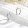 Minimalistische zilverkleurige huggie oorbellen met een rij pavé zirkonia stenen - Pave Ring Stijl / Zilver