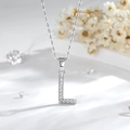 Dettaglio macro del ciondolo lettera L in argento con zirconi su una catena a O - L-Argento