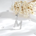 Dettaglio macro del ciondolo a forma di M in argento con zirconi su catena fine - M-Argento